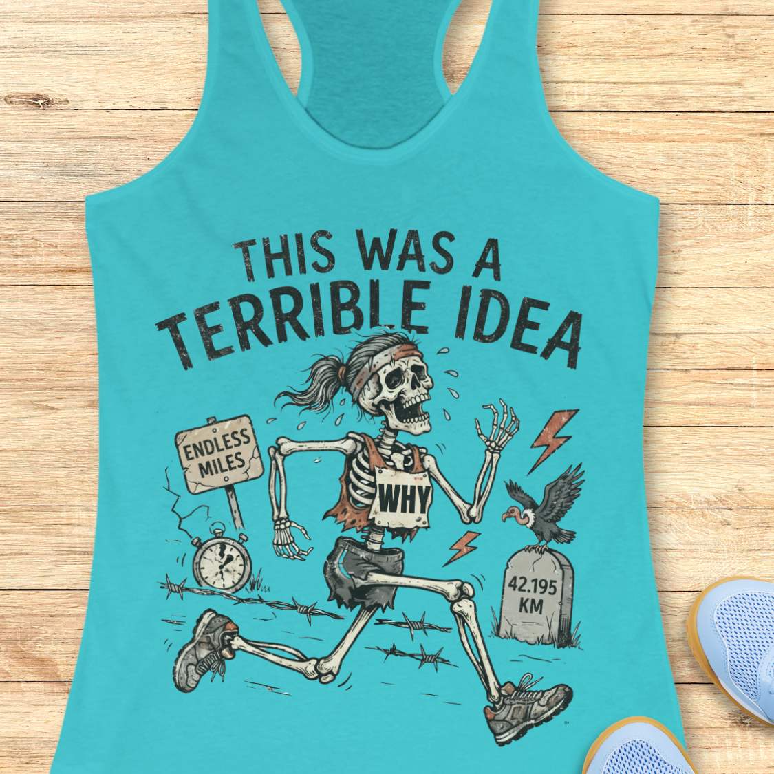 blue tank top with a running skeleton and text 'This was a terrible idea', on a wooden surface