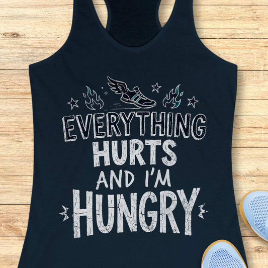 navy tank top with text 'everything hurts and I'm hungry', on a wooden surface