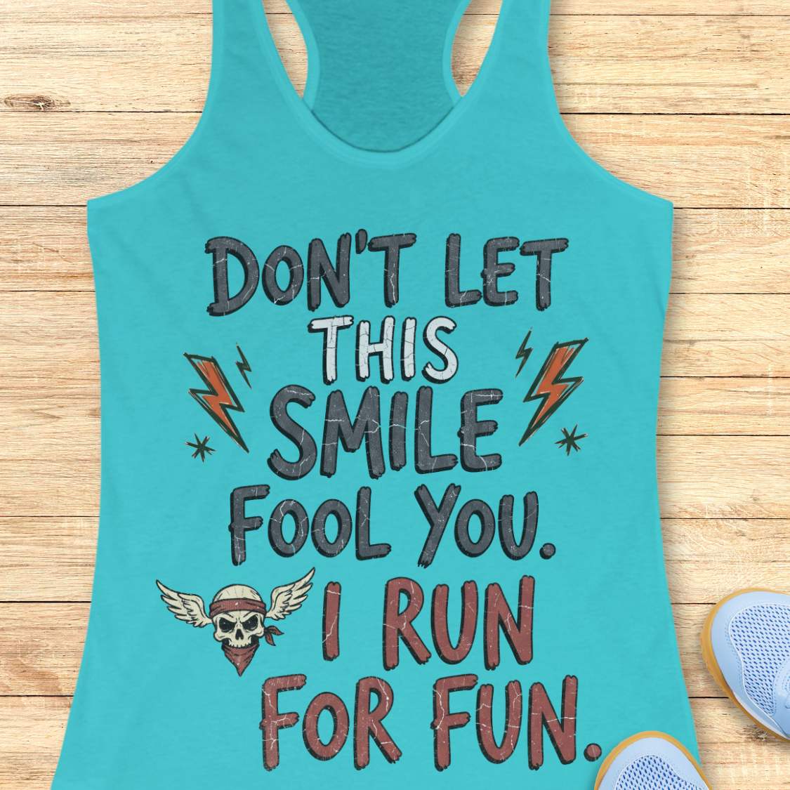 blue tank top with text 'Don't let this smile fool you. I run for fun', on a wooden surface