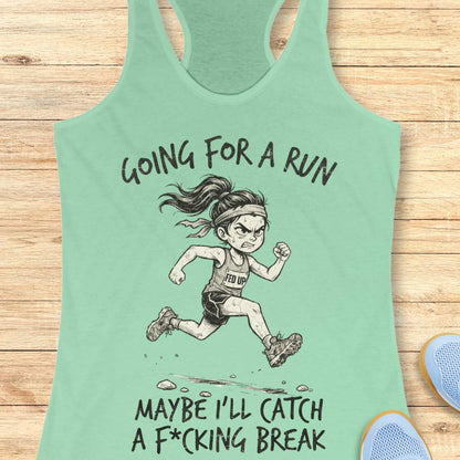 A mint green racerback tank top laid flat on a light wood background, featuring a black line art illustration of an angry female runner with the text 'GOING FOR A RUN' above and 'MAYBE I'LL CATCH A F*CKING BREAK' below.