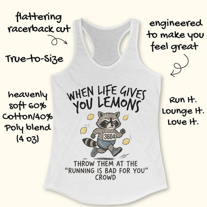 A white racerback tank top with a funny raccoon graphic and text that reads 'WHEN LIFE GIVES YOU LEMONS' and 'THROW THEM AT THE "RUNNING IS BAD FOR YOU" CROWD'. The image has decorative handwritten callouts around the product, all on a light cream background.