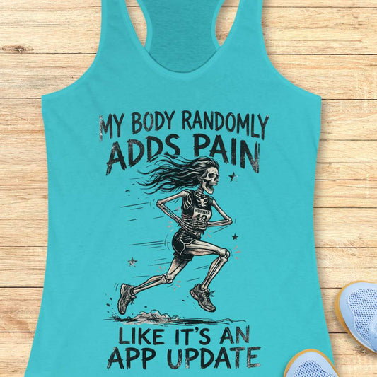 A turquoise racerback tank top laid flat on a light wood surface, featuring a black graphic of a running skeleton and the text 'MY BODY RANDOMLY ADDS PAIN LIKE IT'S AN APP UPDATE'. Part of a blue shoe is visible at the bottom right as a styling prop.