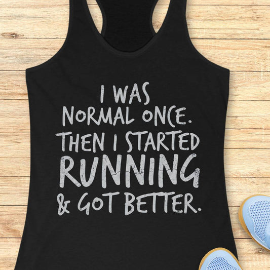 A black racerback tank top with white distressed text reading 'I WAS NORMAL ONCE. THEN I STARTED RUNNING & GOT BETTER.