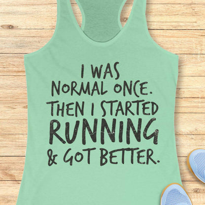 A mint green racerback tank top with black distressed text reading 'I WAS NORMAL ONCE. THEN I STARTED RUNNING & GOT BETTER.