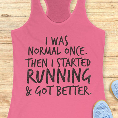 A pink racerback tank top with black distressed text reading 'I WAS NORMAL ONCE. THEN I STARTED RUNNING & GOT BETTER.