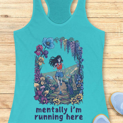A turquoise racerback tank top laid flat on a light wood surface, featuring a colorful graphic of a running skeleton framed by flowers, with the text 'mentally i'm running here' printed below.