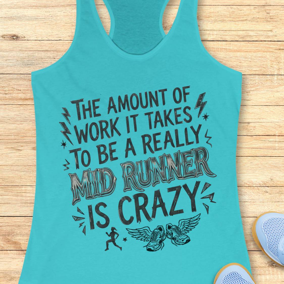A turquoise racerback tank top with a humorous graphic for running, laid flat on a light wood background with a sneaker partially visible in the corner.