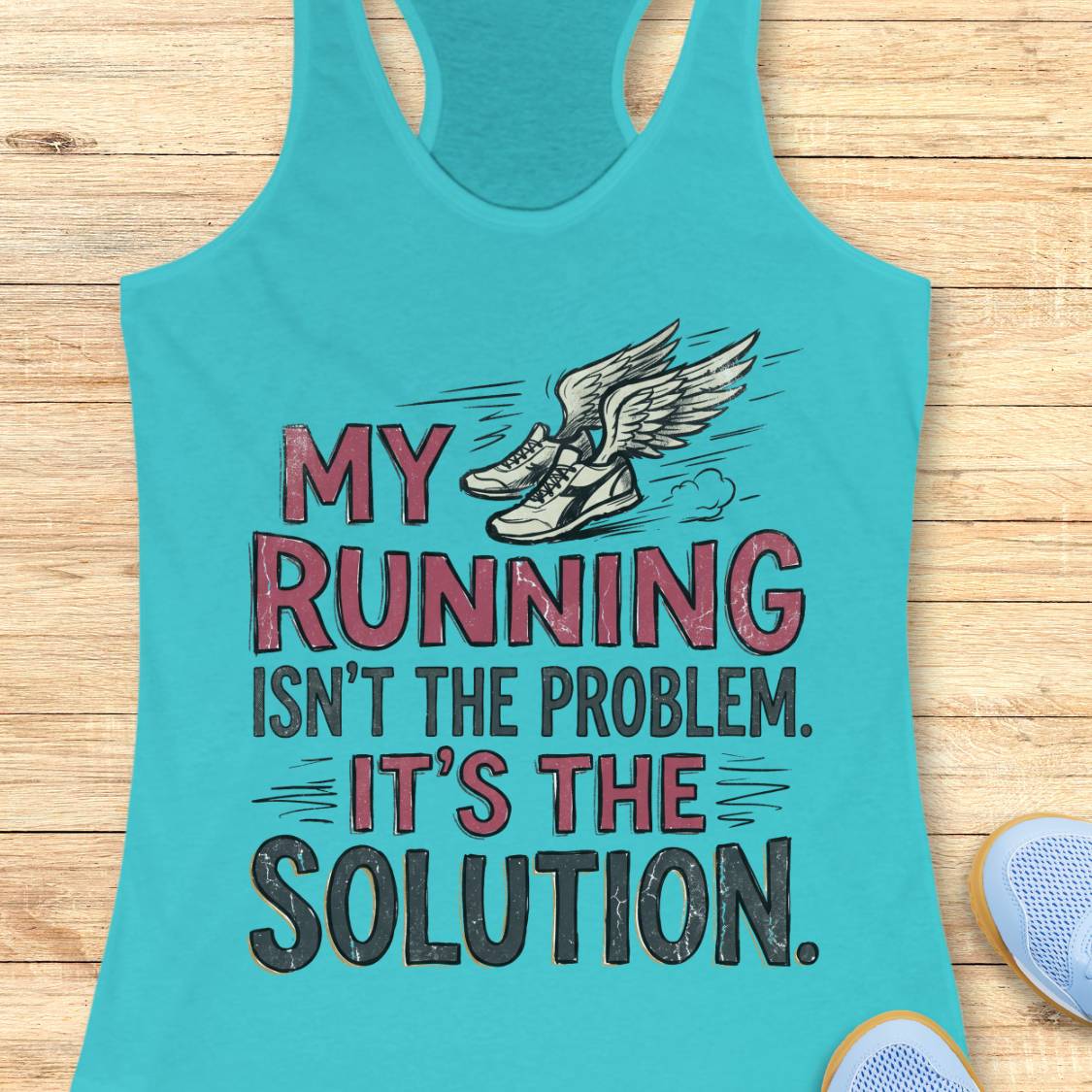 A turquoise racerback tank top laid flat on a light wood background, featuring a graphic of winged running shoes and the text 'MY RUNNING ISN'T THE PROBLEM. IT'S THE SOLUTION.