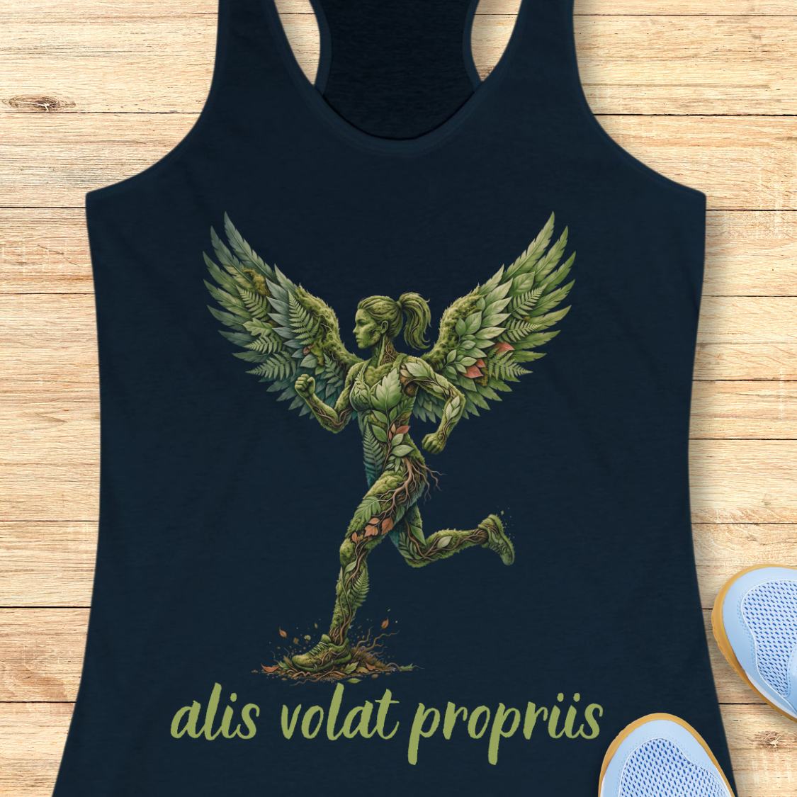 A navy blue racerback tank top featuring a green winged running figure graphic and the text 'alis volat propriis' in light green, laid flat on a light wood background with partial sneakers visible at the edges.