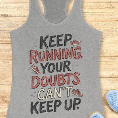 A heather gray racerback tank top with a motivational graphic reading 'KEEP RUNNING YOUR DOUBTS CAN'T KEEP UP' in black and red lettering, styled flat on a light wood background with partial blue sneakers visible at the edges.
