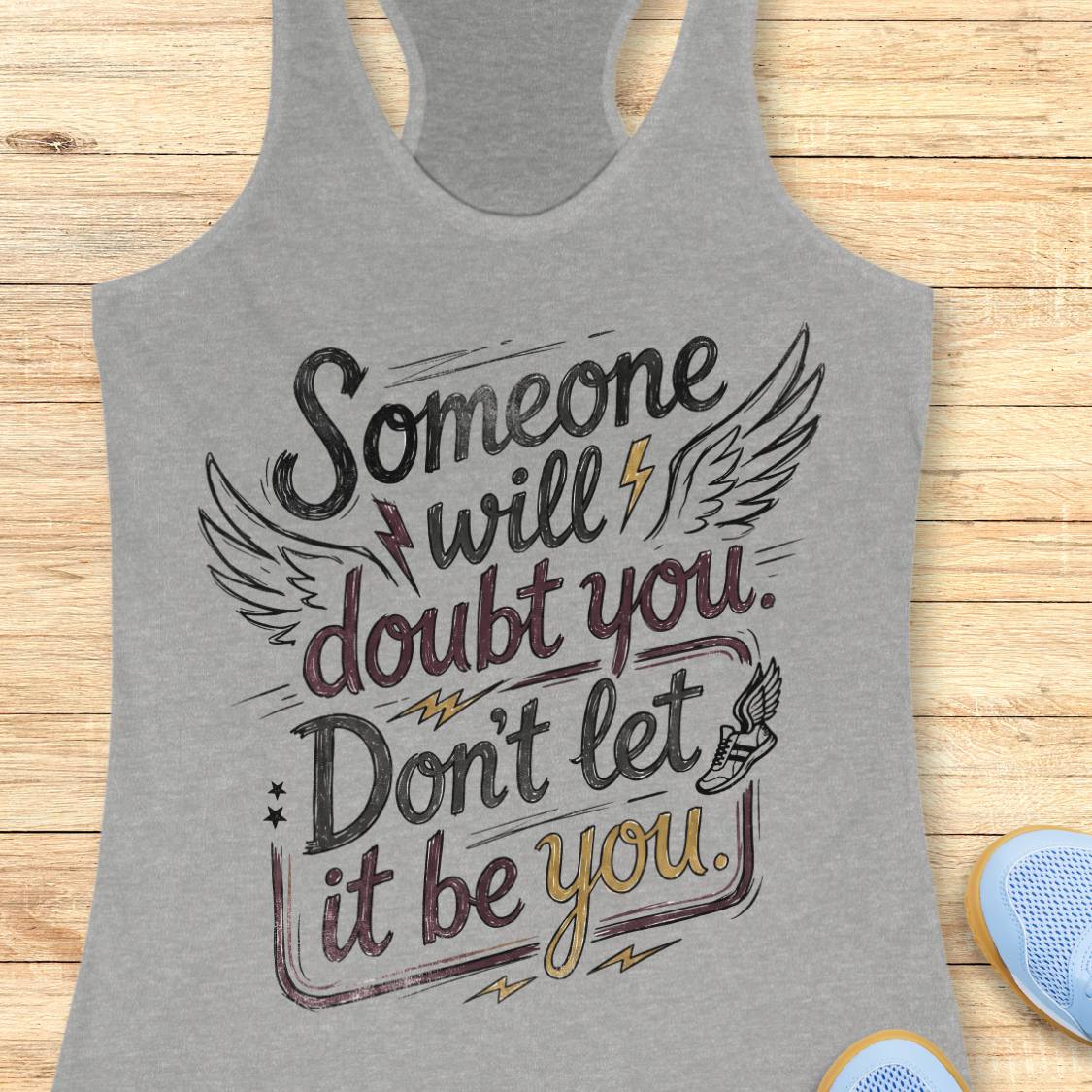 A heather gray racerback tank top with a motivational graphic reading 'Someone will doubt you. Don't let it be you.