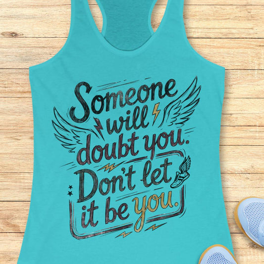 A turquoise racerback tank top laid flat on a light wood surface, featuring a motivational graphic that reads 'Someone will doubt you. Don't let it be you.