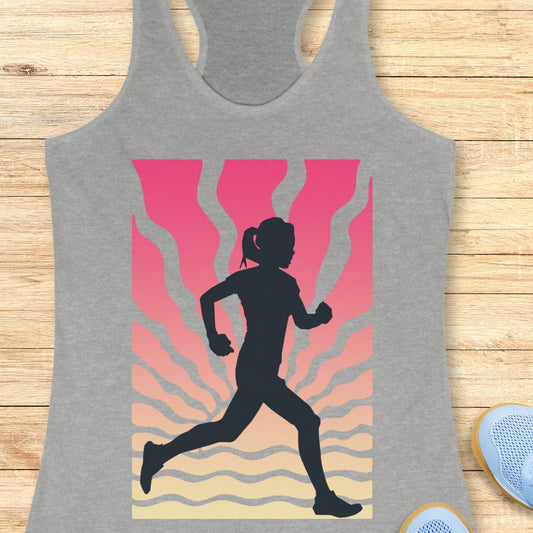 A heather gray racerback tank top featuring a graphic print of a black runner silhouette against a pink, orange, and beige wavy background, displayed flat on a light wood surface.