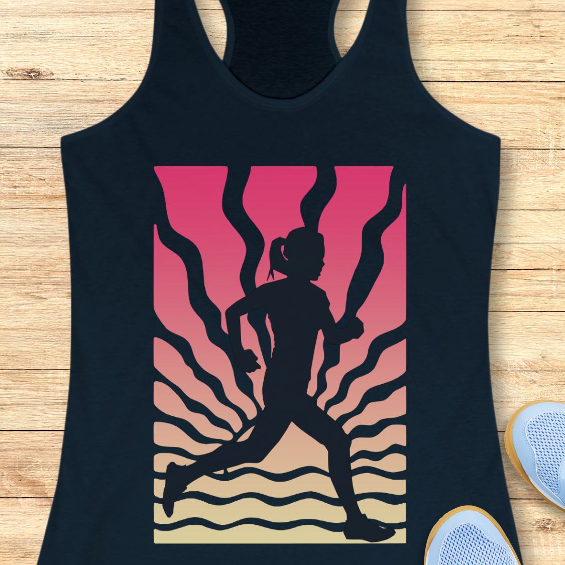 A navy racerback tank top laid flat on a light wood background, featuring a large graphic print of a running silhouette against a pink-to-beige gradient with wavy black lines. Part of a white sneaker is visible at the bottom right.