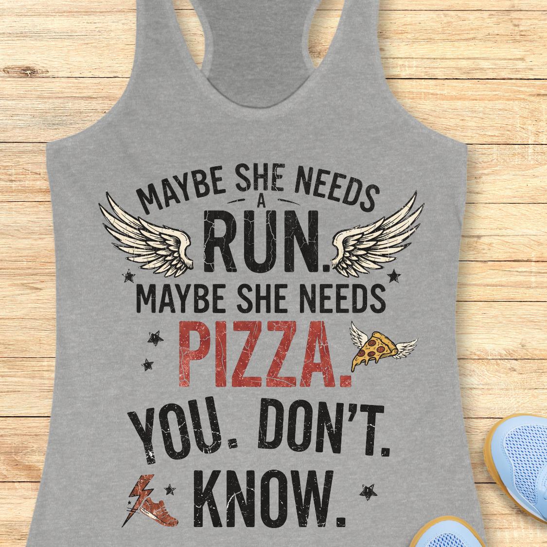 A heather gray racerback tank top with a humorous graphic print, displayed flat on a light wood background. The graphic reads 'MAYBE SHE NEEDS A RUN.
