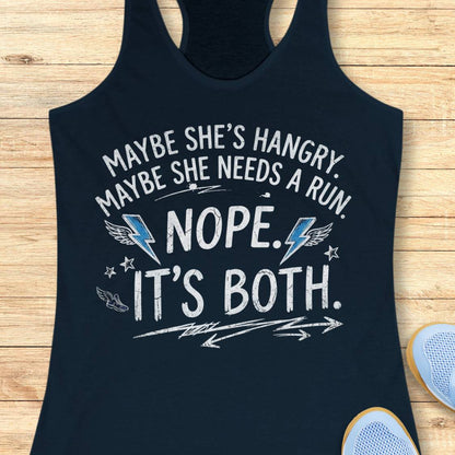 A navy racerback tank top laid flat on a light wood surface, featuring a humorous white graphic text that reads 'MAYBE SHE'S HANGRY. MAYBE SHE NEEDS A RUN.