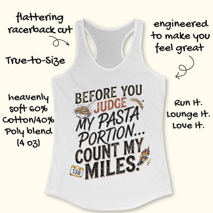 A white racerback tank top featuring  the text 'before you judge my pasta portion...count my miles ' printed on the front, displayed flat on a light wood background.
