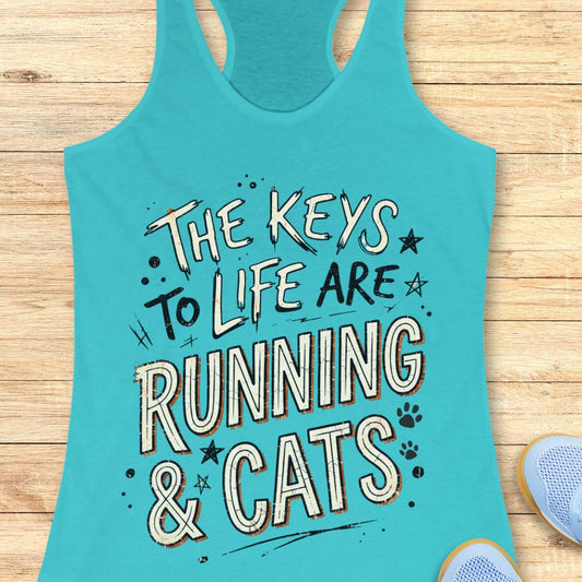 A blue racerback tank top laid flat on a light wood surface, featuring the phrase 'THE KEYS TO LIFE ARE RUNNING & CATS' in white and blue outlined lettering with small paw print and star accents. Part of a light blue shoe is visible at the bottom right.