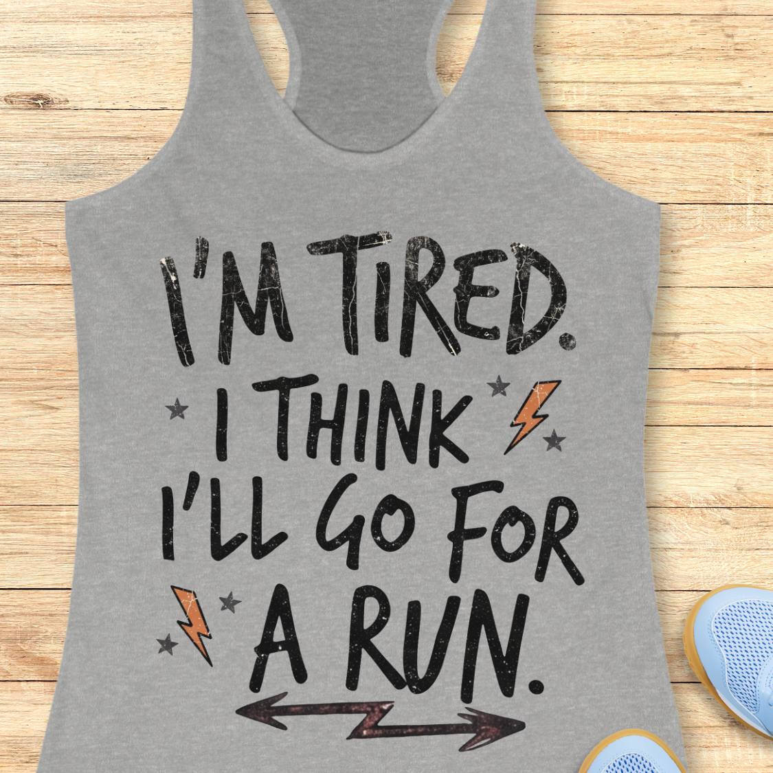 A heather gray racerback tank top with a motivational graphic that reads 'I'M TIRED. I THINK I'LL GO FOR A RUN.