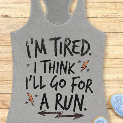A heather gray racerback tank top with a motivational graphic that reads 'I'M TIRED. I THINK I'LL GO FOR A RUN.