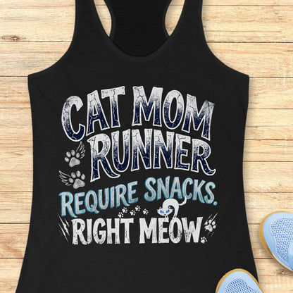 A black racerback tank top laid flat on a light wood background, featuring the text 'CAT MOM RUNNER REQUIRE SNACKS. RIGHT MEOW.