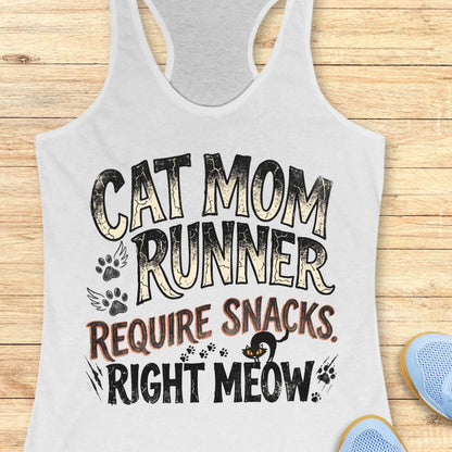 A white racerback tank top laid flat on a light wood surface, featuring a distressed graphic that reads 'CAT MOM RUNNER REQUIRE SNACKS. RIGHT MEOW.