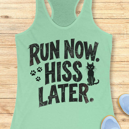 A mint green racerback tank top with a black distressed graphic reading 'RUN NOW. HISS LATER.