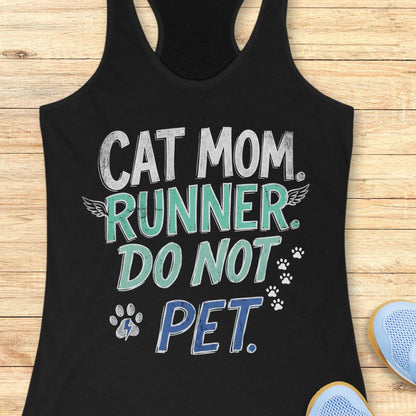 A black racerback tank top laid flat on a light wood surface, featuring the text 'CAT MOM. RUNNER.