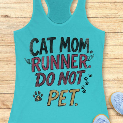 A turquoise racerback tank top laid flat on a light wood background, featuring the printed phrase 'CAT MOM. RUNNER.
