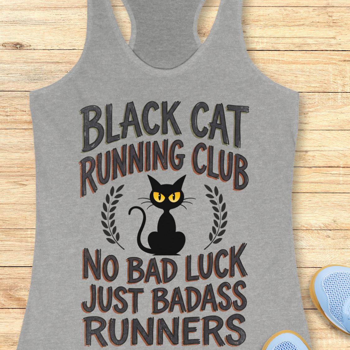 A heather gray racerback tank top laid flat on a light wood background, featuring a black cat graphic with yellow eyes and the text 'BLACK CAT RUNNING CLUB' and 'NO BAD LUCK JUST BADASS RUNNERS.' A small portion of a blue shoe is visible at the lower right edge.