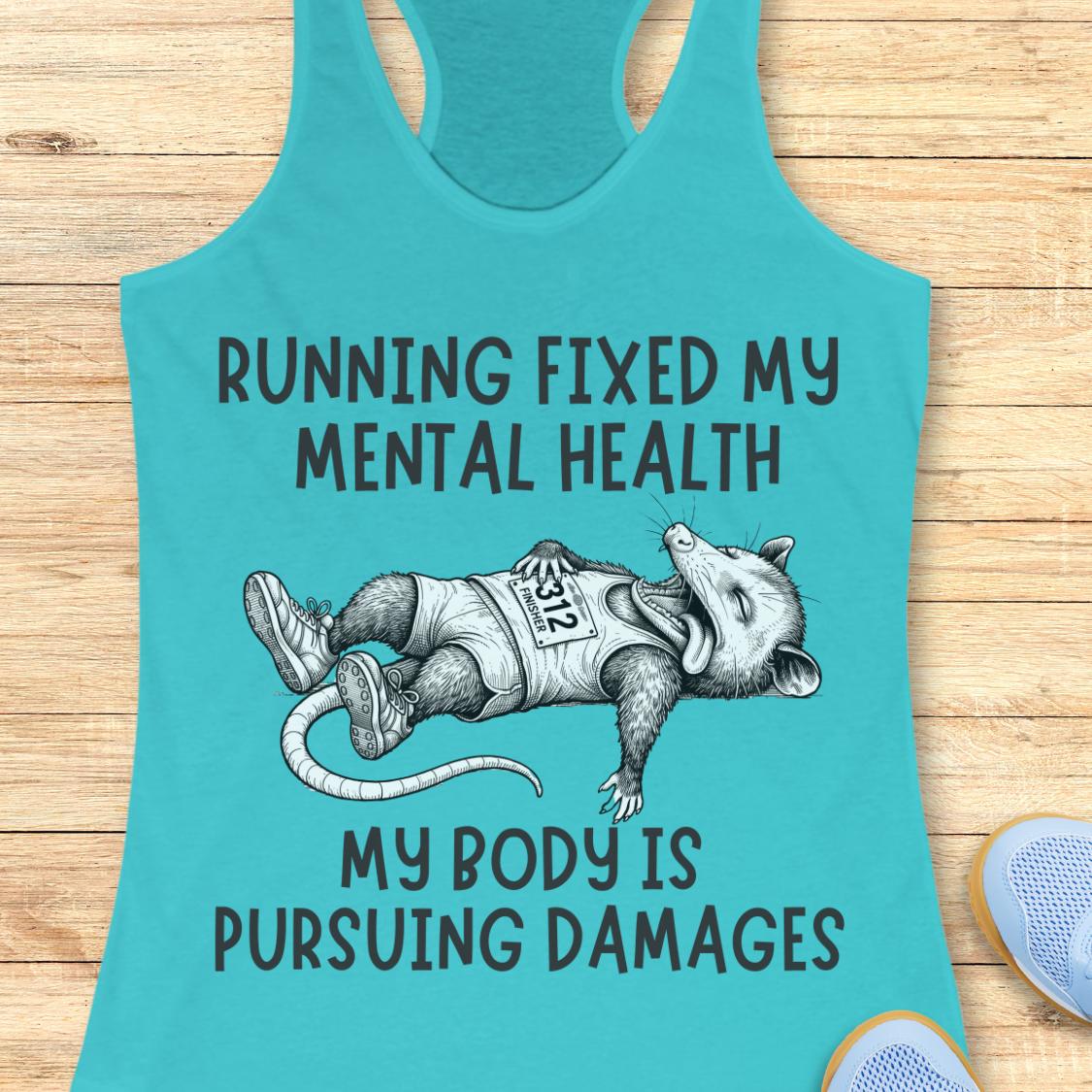 A turquoise racerback tank top laid flat on a light wood surface, featuring a humorous graphic of a sleeping runner with the text 'RUNNING FIXED MY MENTAL HEALTH' and 'MY BODY IS PURSUEING DAMAGES'.