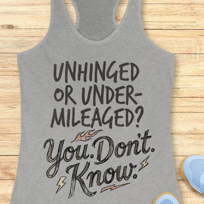 A heather gray racerback tank top with a motivational graphic reading 'UNHINGED OR UNDER-MILEAGED? You Don't. Know.