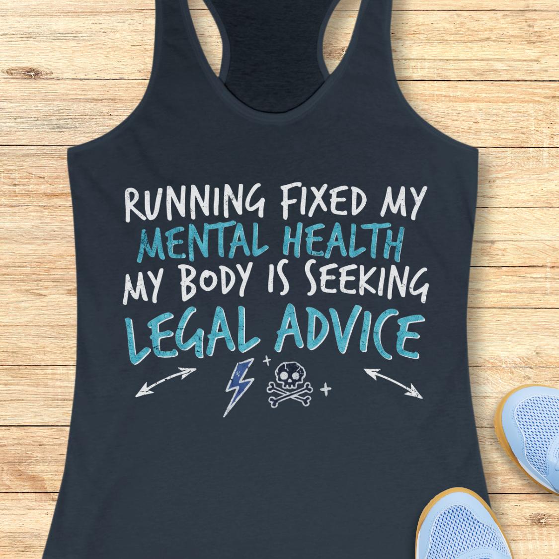 A indigo racerback tank top laid flat on a light wood surface, featuring the text 'RUNNING FIXED MY MENTAL HEALTH MY BODY IS SEEKING LEGAL ADVICE' in white and light blue lettering, with small white graphic icons below. Partial blue sneakers are visible at the bottom right as styling props.