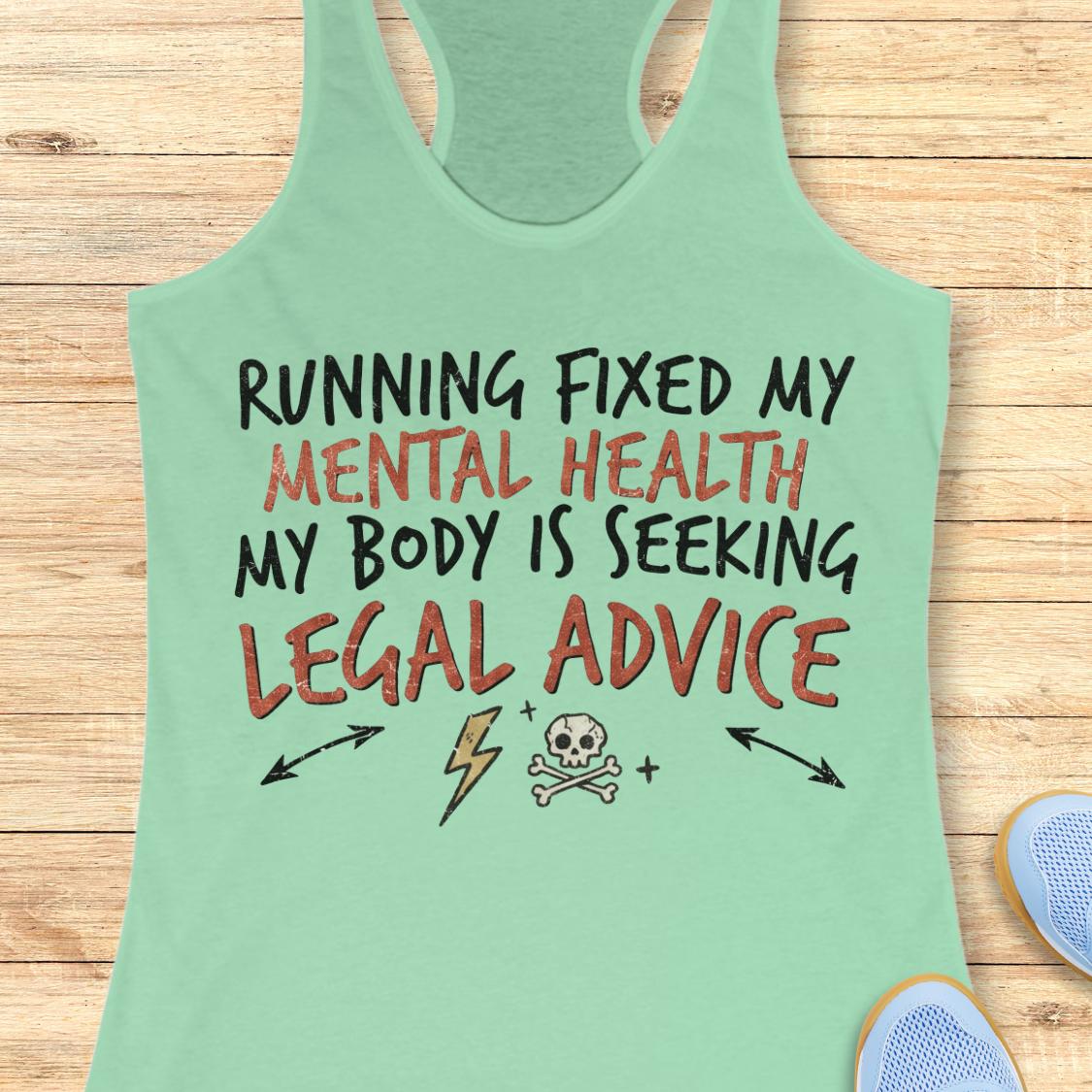 A mint green racerback tank top laid flat on a light wood background, featuring a graphic text design that reads 'RUNNING FIXED MY MENTAL HEALTH MY BODY IS SEEKING LEGAL ADVICE' with black and orange lettering and small illustrative icons below.