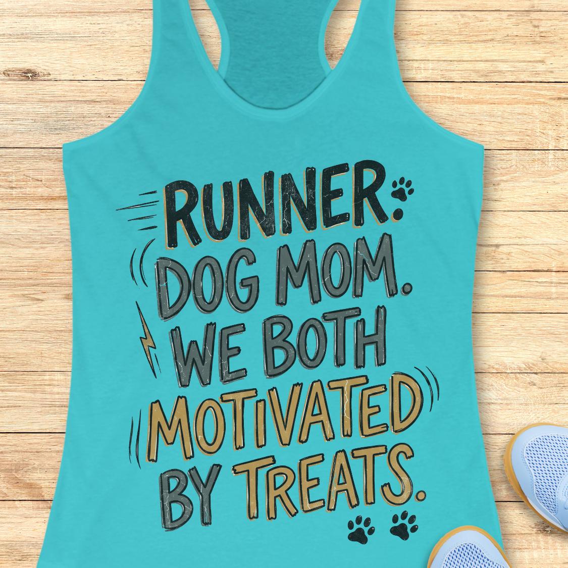 A turquoise racerback tank top laid flat on a light wood surface, printed with the phrase “RUNNER DOG MOM WE BOTH MOTIVATED BY TREATS.” in black and tan lettering with small paw print and lightning bolt graphics.