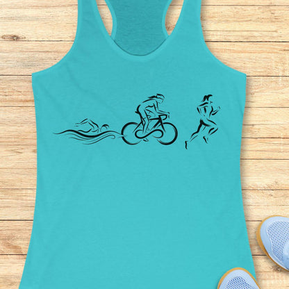 A turquoise racerback tank top with a black graphic of a swimmer, cyclist, and runner, laid flat on a light wood plank background.