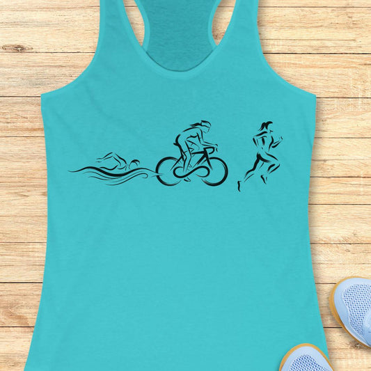 A turquoise racerback tank top with a black graphic of a swimmer, cyclist, and runner, laid flat on a light wood plank background.