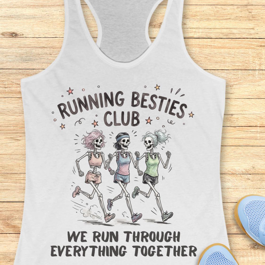 A white racerback tank top laid flat on a light wood background, featuring a printed graphic of three running skeletons with the text 'RUNNING BESTIES CLUB' and 'WE RUN THROUGH EVERYTHING TOGETHER.' A blue shoe is partially visible at the lower right as a styling prop.