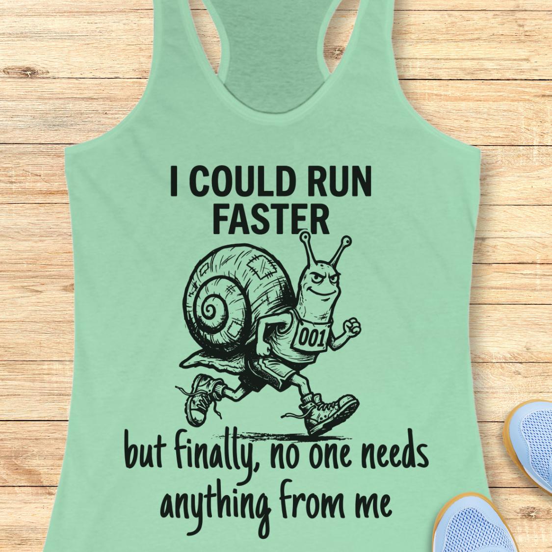 A mint green racerback tank top laid flat on a light wood background, featuring a black graphic of a snail running with the text 'I COULD RUN FASTER but finally, no one needs anything from me'.