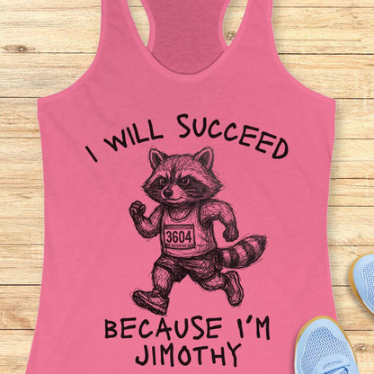 A pink racerback tank top laid flat on a light wood surface, featuring a black line-art raccoon running with the text 'I WILL SUCCEED BECAUSE I'M JIMOTHY'. Partial blue shoes are visible at the edges as styling props.