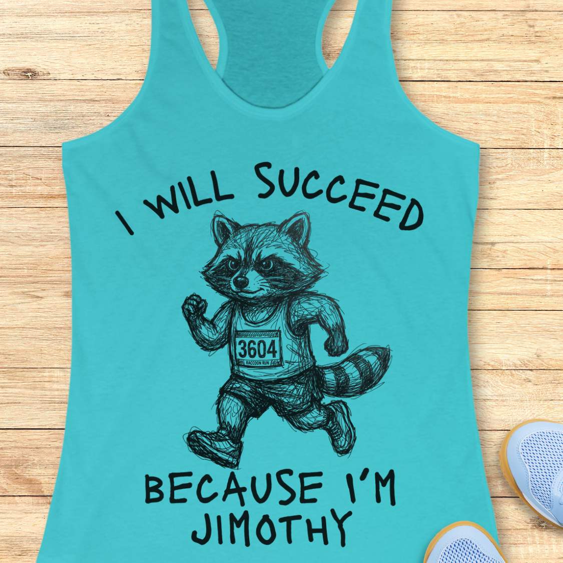 A turquoise racerback tank top laid flat on a light wood surface, featuring a black graphic of a running raccoon wearing a race bib and the text 'I WILL SUCCEED BECAUSE I'M JIMOTHY'. A partial white sneaker is visible at the bottom right.