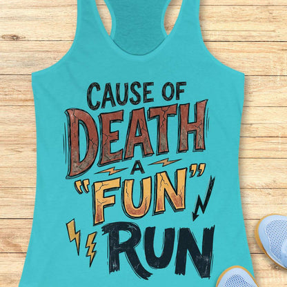 A turquoise racerback tank top laid flat on a light wood surface, featuring the graphic text 'CAUSE OF DEATH A "FUN" RUN' in black, brown, and orange lettering with small lightning bolt accents. Partial shoes are visible at the bottom right as styling props.