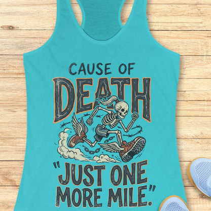 A turquoise racerback tank top laid flat on a light wood surface, featuring a graphic of a skeleton running with a shoe and the text 'CAUSE OF DEATH "JUST ONE MORE MILE".' A partial blue shoe is visible at the bottom right as a styling prop.