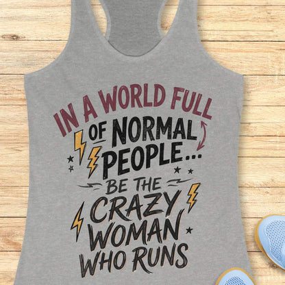A heather gray racerback tank top with a graphic print that reads 'IN A WORLD FULL OF NORMAL PEOPLE.