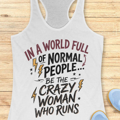 A light heather gray racerback tank top with a motivational graphic print reading 'IN A WORLD FULL OF NORMAL PEOPLE.