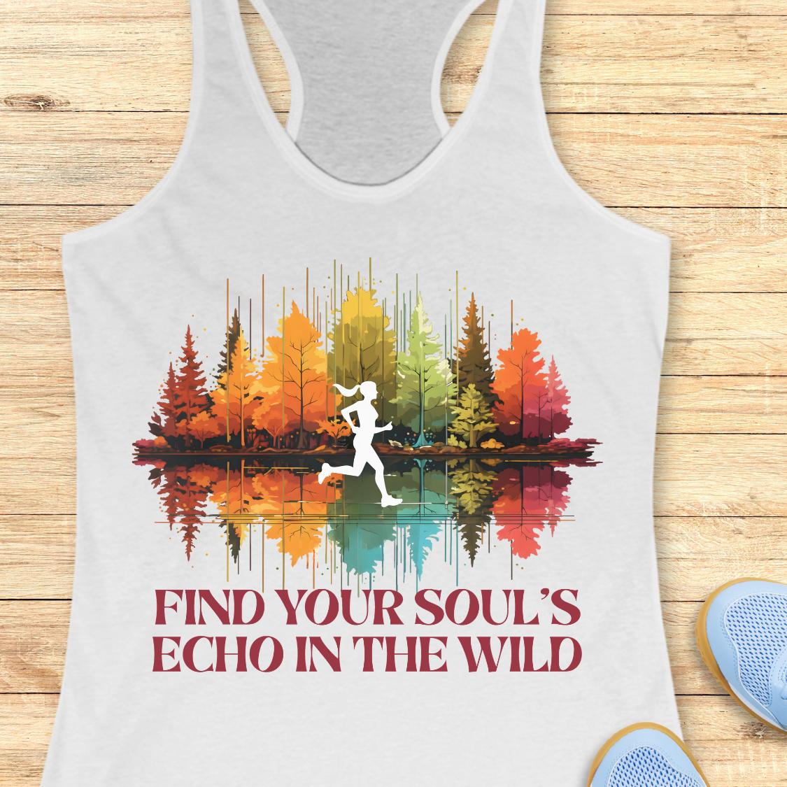 A white racerback tank top laid flat on a light wood surface, featuring a colorful forest and lake graphic with a white running silhouette and the text 'FIND YOUR SOUL'S ECHO IN THE WILD.' Partial blue sneakers are visible at the lower right as styling props.