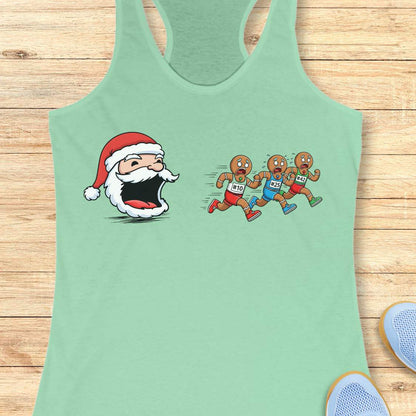 mint tank top featuring a cartoon Santa head with a surprised expression chasing three gingerbread men wearing red blue and green shorts with race bibs #10 #25 #42 on a wooden background with white earbuds and a blue athletic shoe