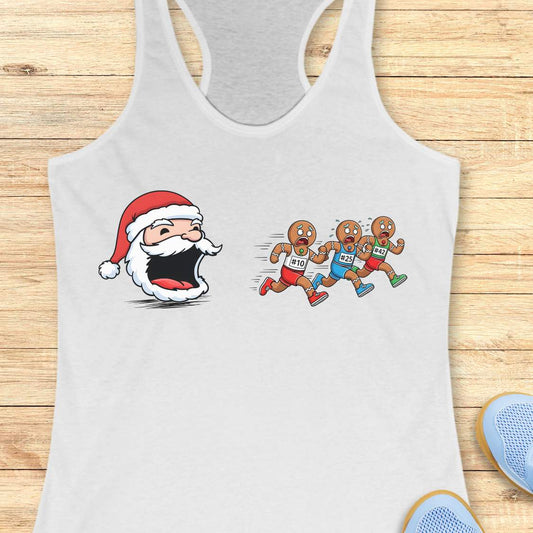 White tank top featuring a cartoon Santa head with a surprised expression chasing three gingerbread men wearing red blue and green shorts with race bibs #10 #25 #42 on a wooden background with white earbuds and a blue athletic shoe