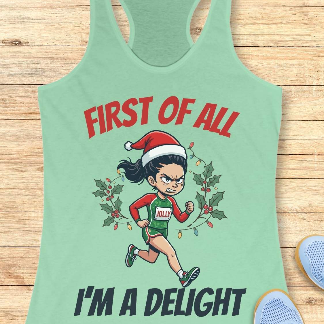 Mint green running tank top featuring a cartoon holiday runner wearing a Santa hat and a race singlet labeled 'JOLLY.' The runner is surrounded by holly leaves and colorful Christmas lights. The design includes the phrase 'FIRST OF ALL I'M A DELIGHT.'