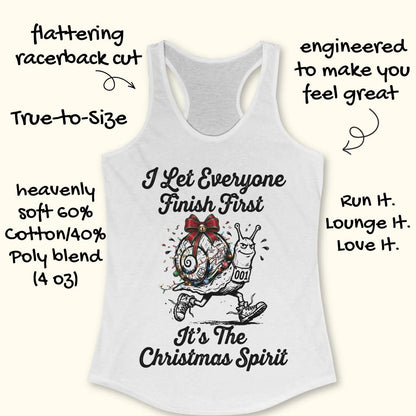 A white racerback tank top laid flat on a light wood background, featuring a black graphic of a decorated snail running with the text 'I Let Everyone Finish First It's The Christmas Spirit'.